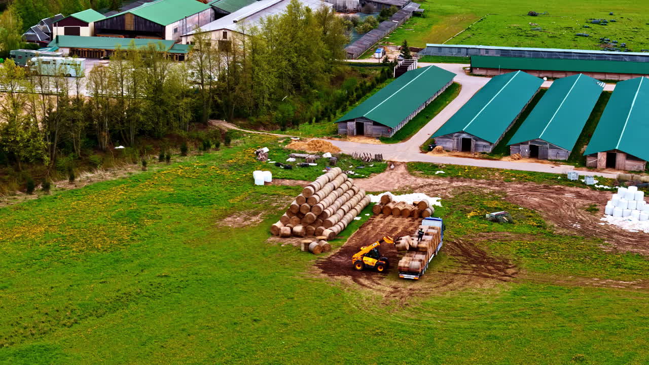 Tracking orbit of tractors loading peat onto trucks at large agriculture prep area