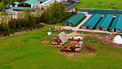 tracking orbit of tractors loading peat onto trucks at large agriculture prep area