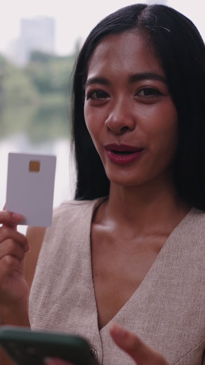 Donna che tiene la carta di credito e utilizzando il telefono cellulare