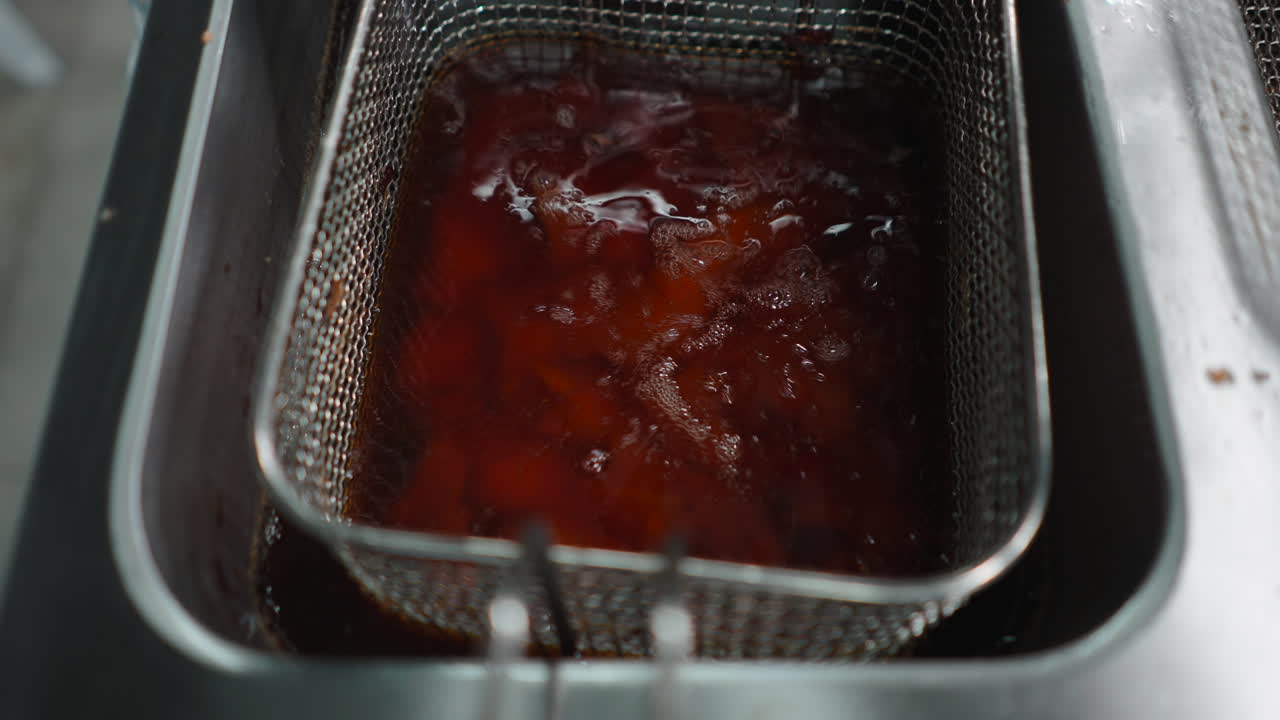 Food being deep fried in a fryer basket