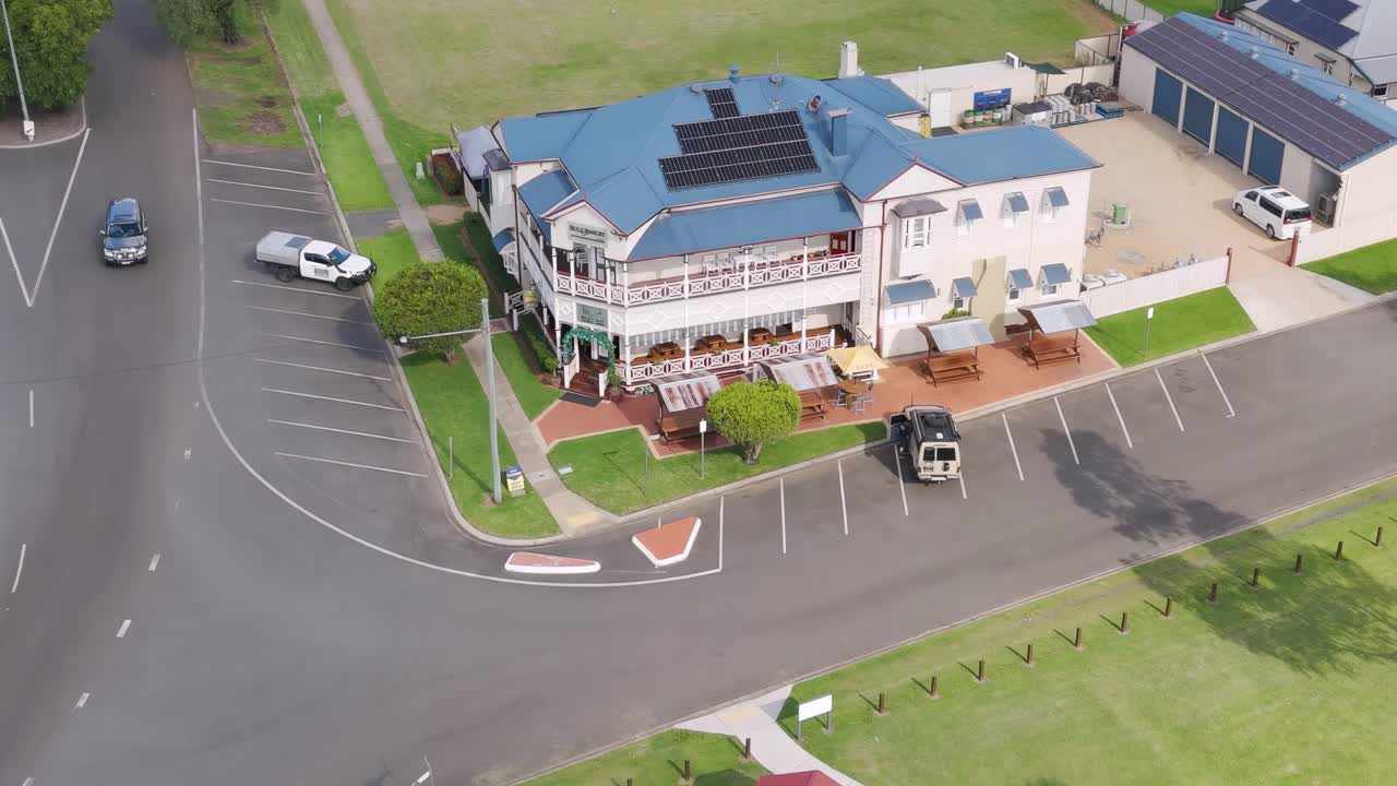 Aerial footage showing a rural intersection with a prominent building and surrounding greenery.