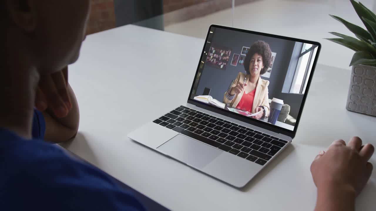 Mid section of african american woman having a video call with female colleague on laptop at office