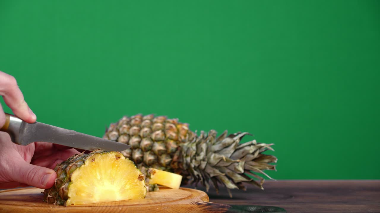 손은 신선한 파인애플을 조각으로 잘라습니다.