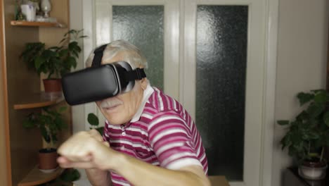 grandmother in virtual headset glasses watching video in vr helmet training box, shows fist fight