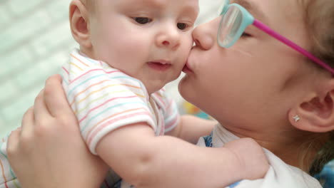 sister kissing baby brother. sweet family love. older sister hugging cute infant