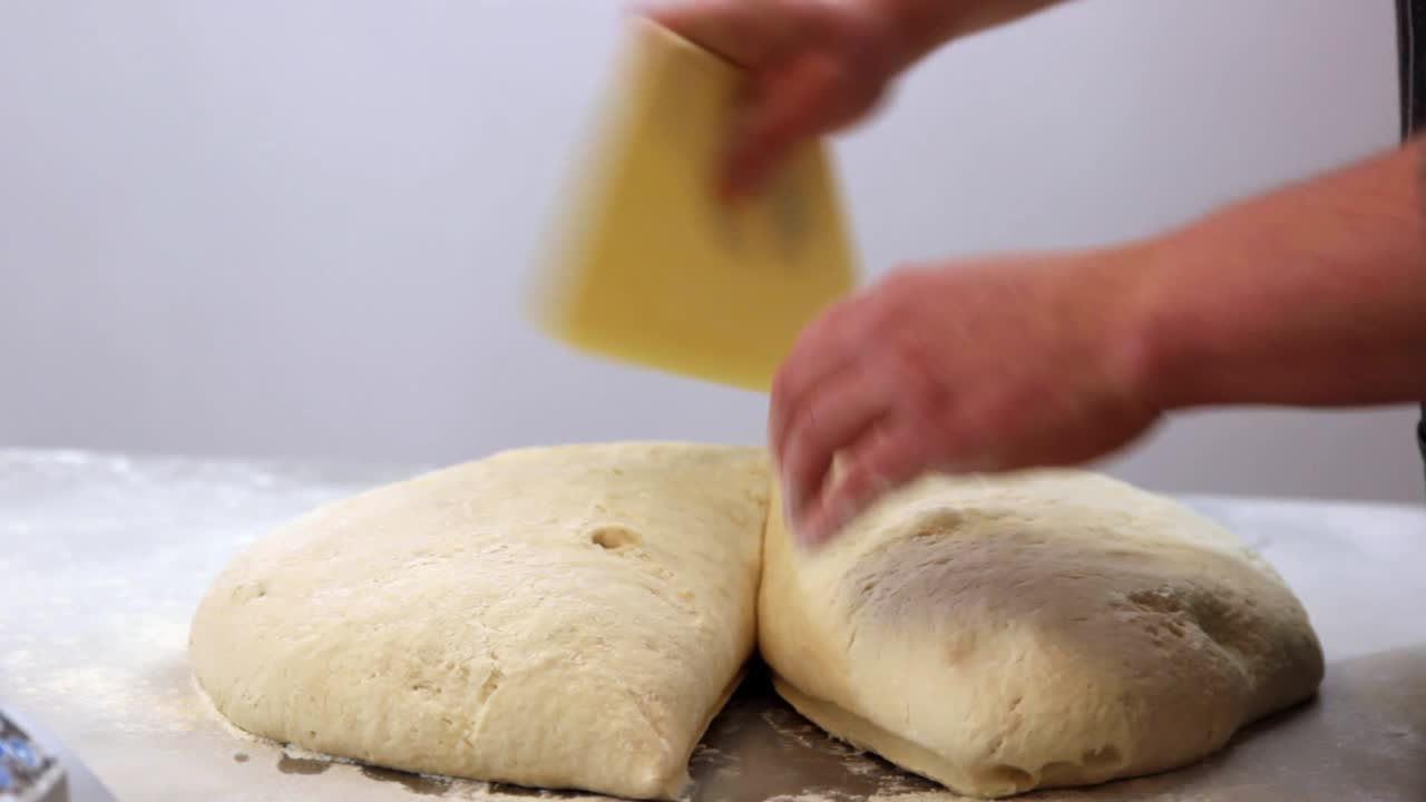baker dividing dough and weighing, close