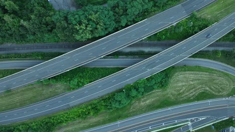 aerial view of highway interchange with railroad tracks and lush green landscape
