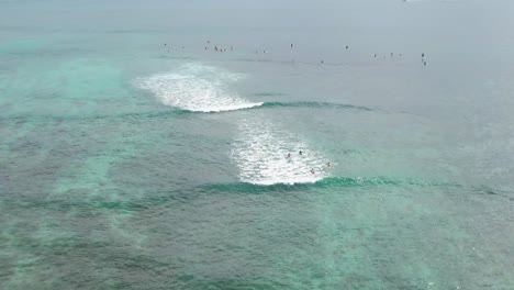 Surfistas-Sentados-En-El-Agua-Esperando-Olas,-Alta-Vista-Aérea