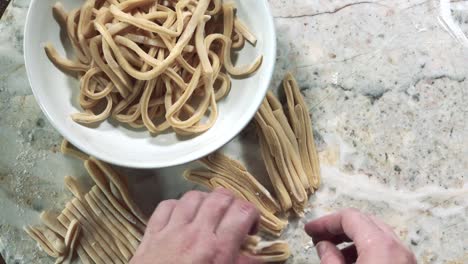 hands opening up pasta dough noodles