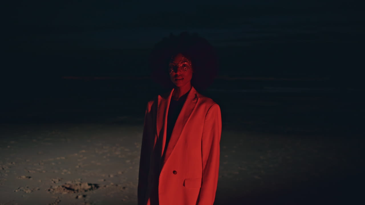 Party girl posing beach in red light at night. Stylish   at shore