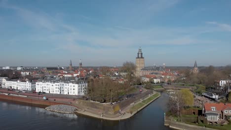 aerial approach of medieval hanseatic city zutphen, the netherlands, with entrance to small vispoorthaven or gelre port connected to the river ijssel against a bright blue sky with clouds