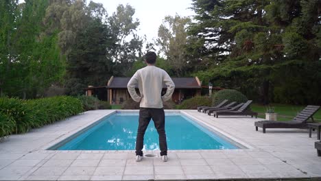 back of a man standing in front of a swimming pool outside vacation villas