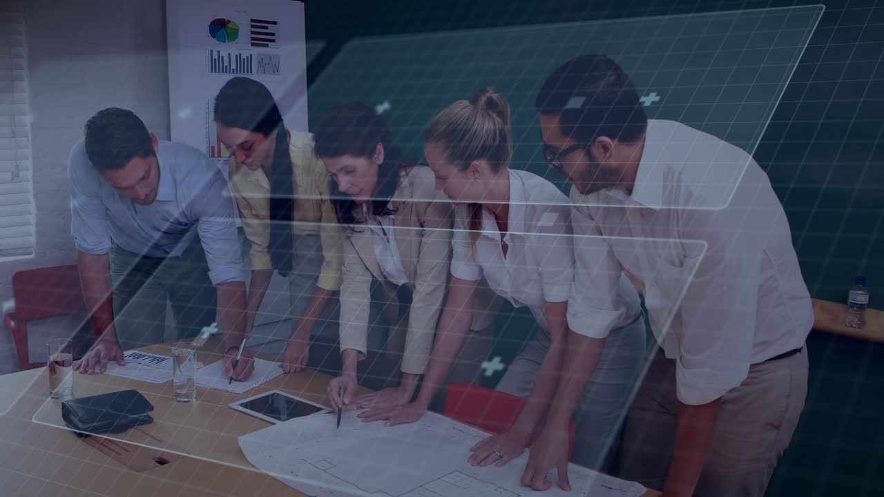 Design team reviewing and marking blueprints on meeting table, tablet activating rotating AR grid