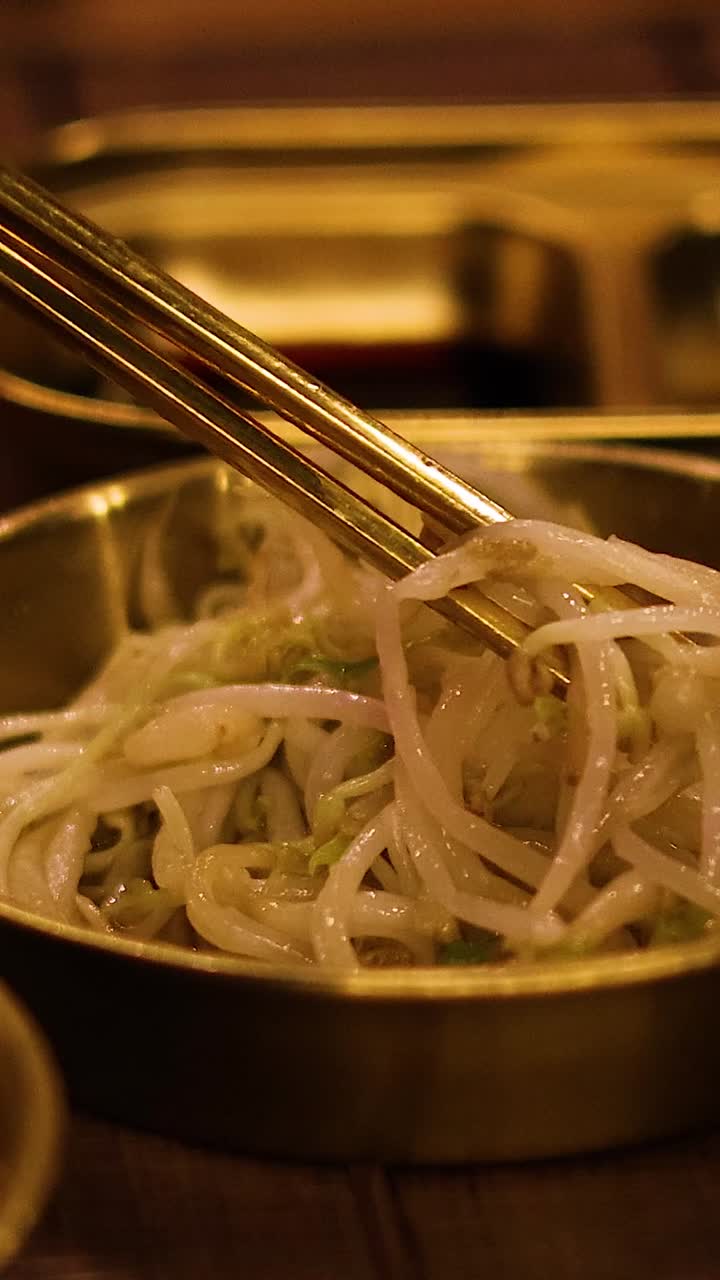 palillos para comer levantando brotes de frijol mungo del cuenco
