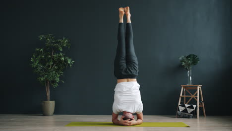 man performing headstand yoga pose