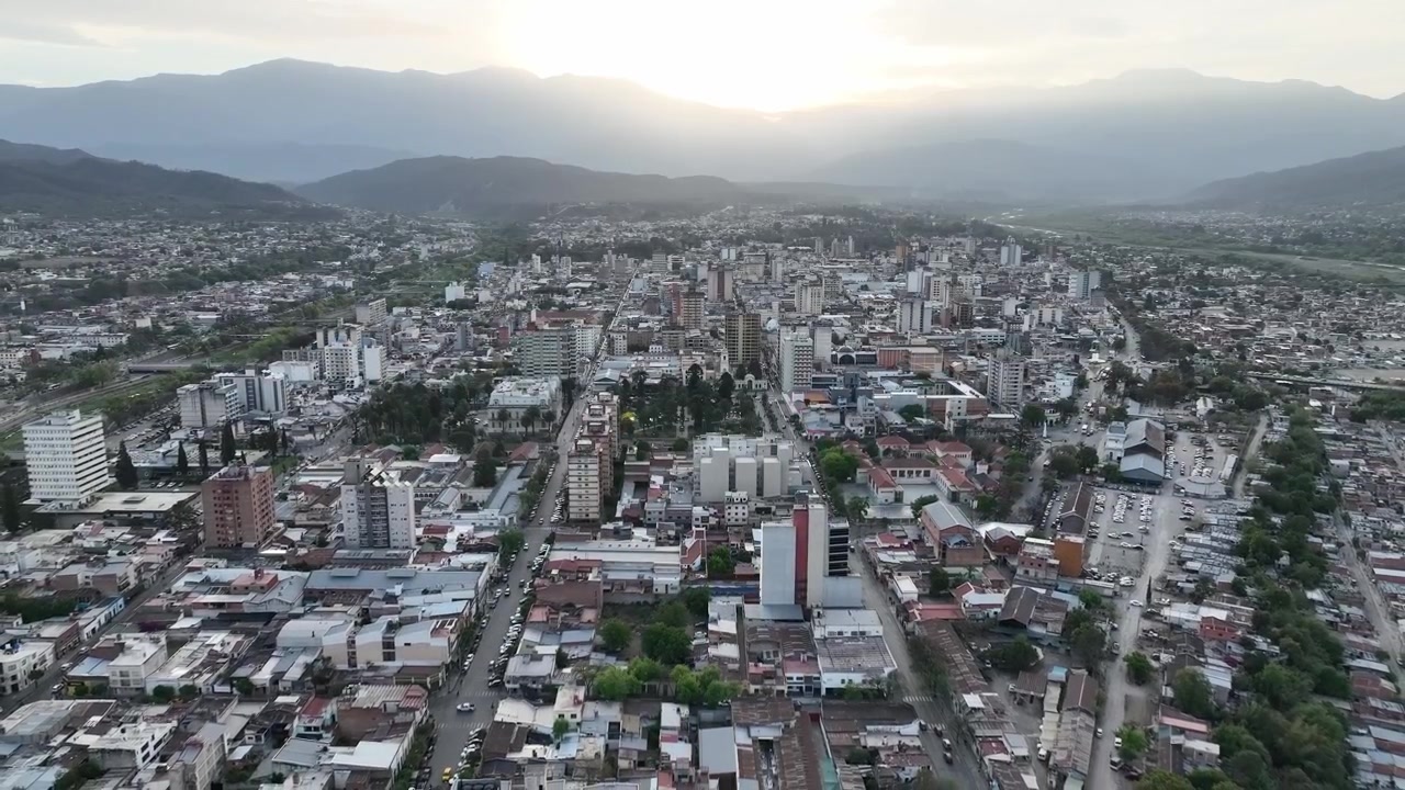 Una vista panoramica aerea elevata e in allontanamento mostra gli edifici della città di Salta, in Argentina, al tramonto