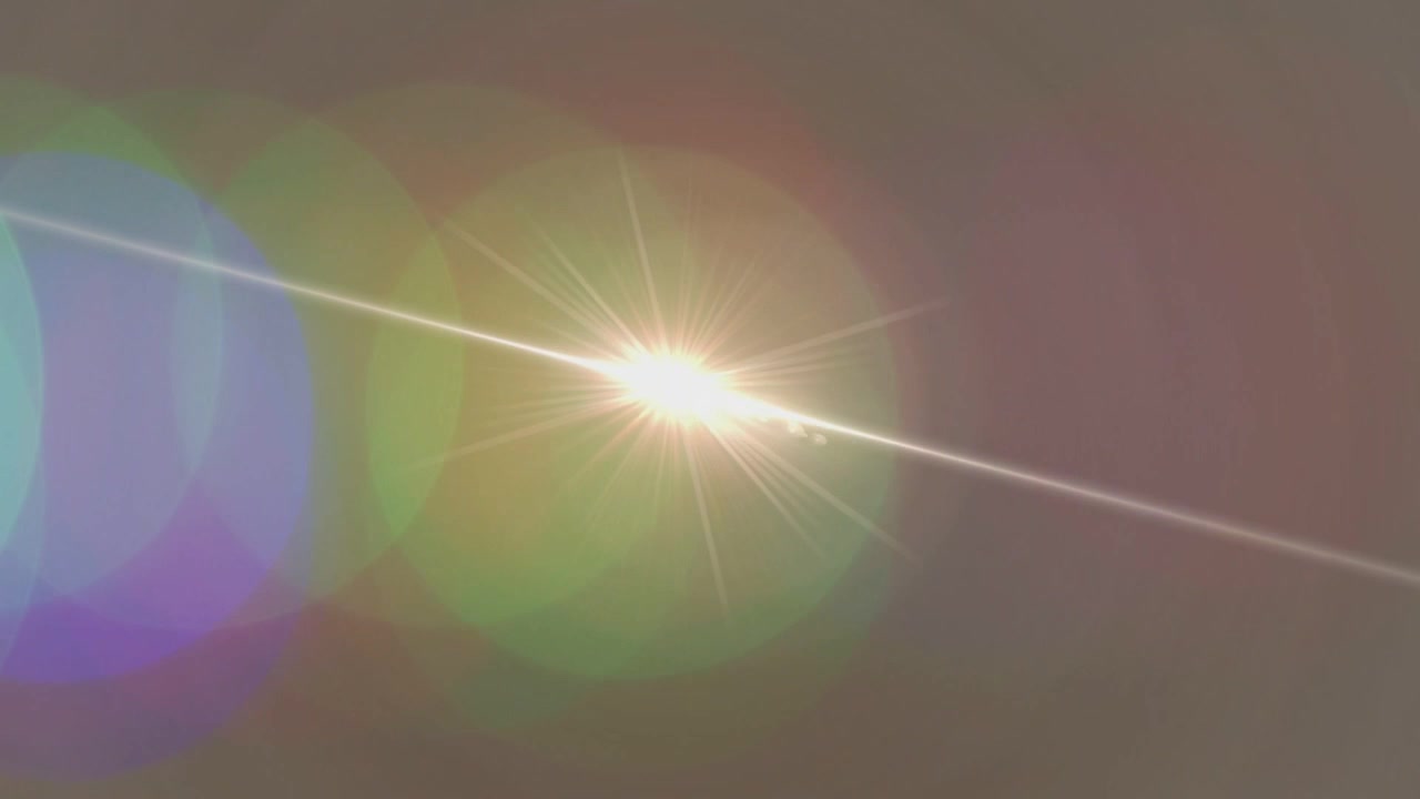 Luce in alto a sinistra che si muove in diagonale creando un effetto starburst, bagliori fantasma e bokeh mutevole, testando l'obiettivo.