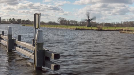 vista a través del agua de knipmolen, histórico molino de viento de madera en voorschoten, países bajos