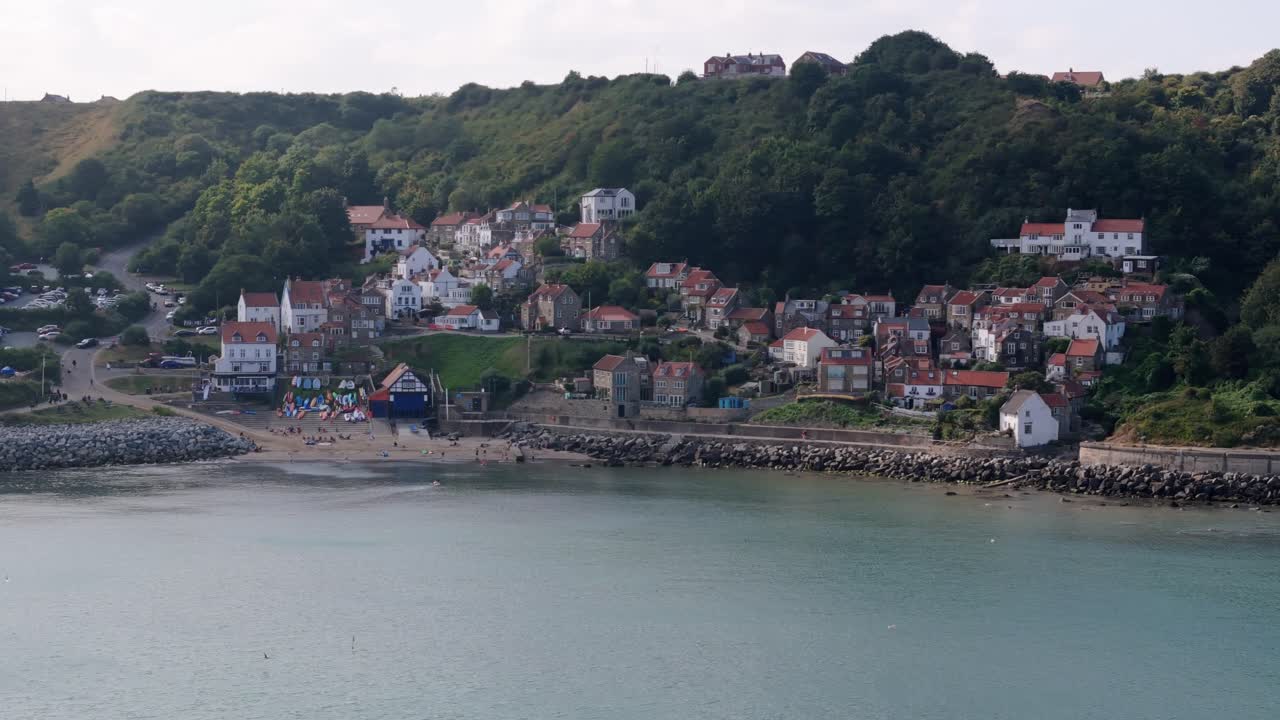 imágenes aéreas de runswick bay, un pintoresco pueblo en el norte de yorkshire con acantilados, océano y una playa de arena con cabañas y el campo