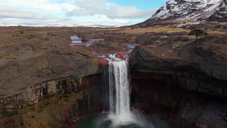 aerial reveal of salto del agrio waterfall, volcanic canyon, argentine patagonia slow motion landscape
