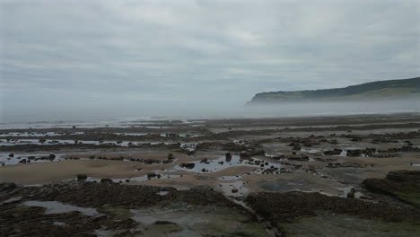 Niedrige-Flugdrohnenaufnahme-Am-Nebligen-Morgen-An-Der-Küste-Von-North-Yorkshire-In-Der-Nähe-Von-Robin-Hood&#39;s-Bay