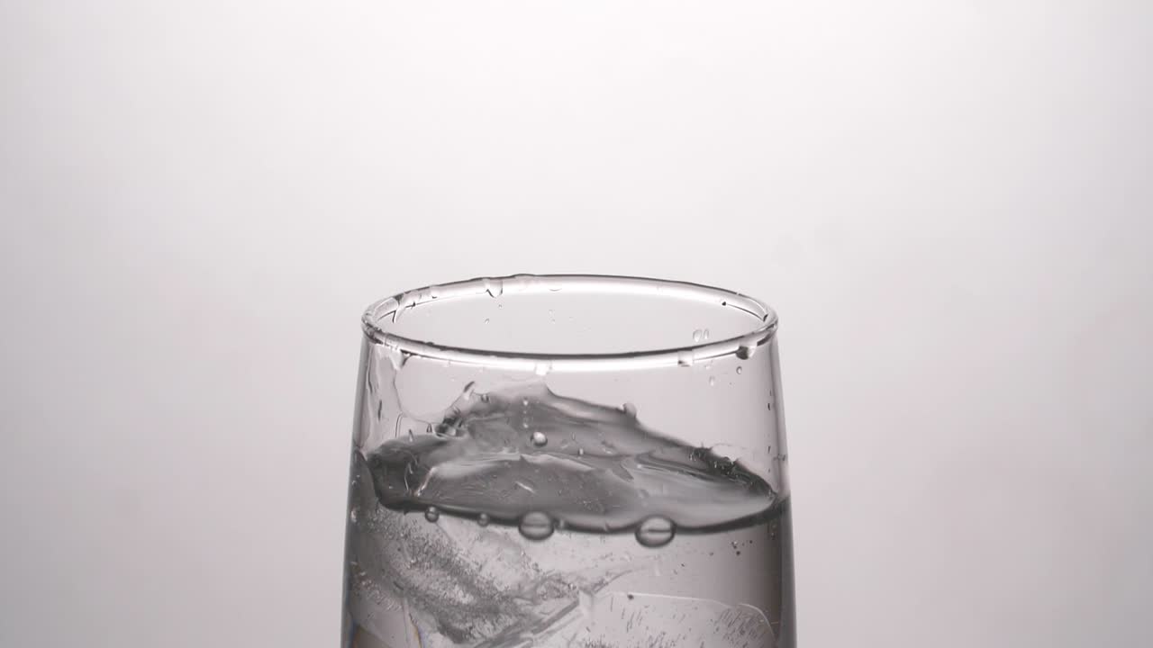 얼음 이 있는 유리잔 에 물 을 부어 넣는 것