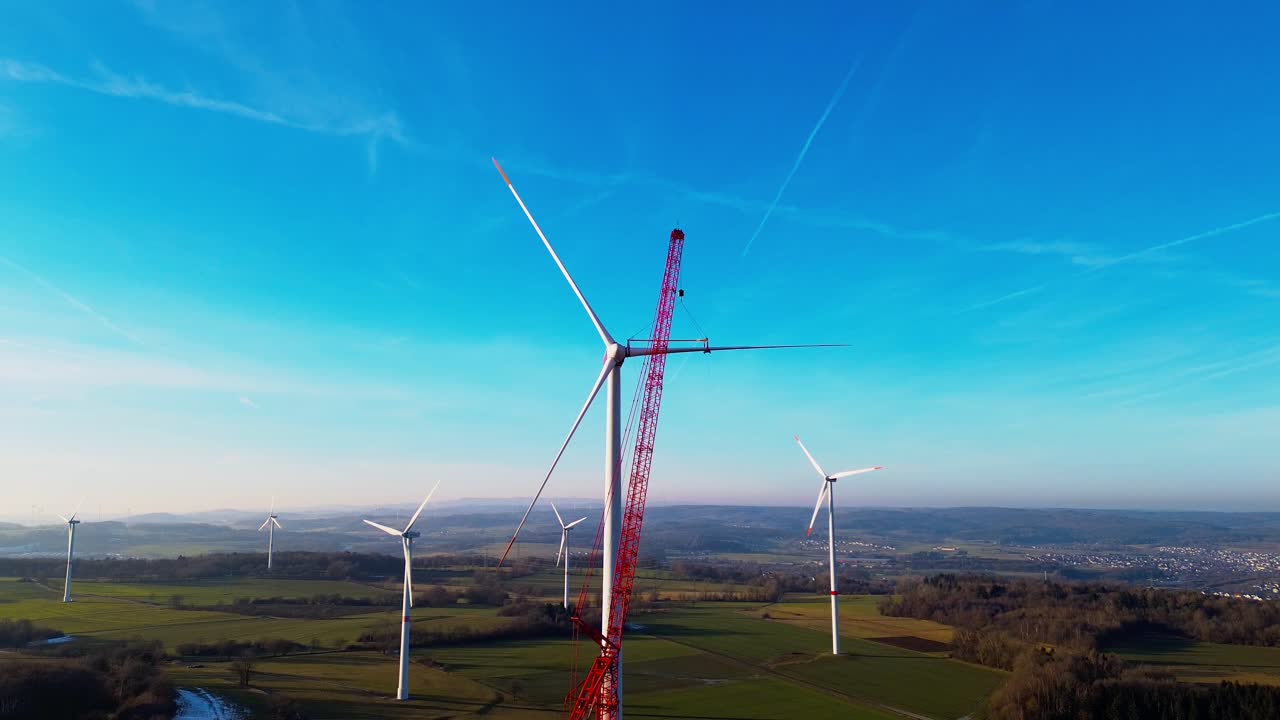 Vista aerea ravvicinata dell'installazione di una turbina eolica con gru nella Germania rurale.