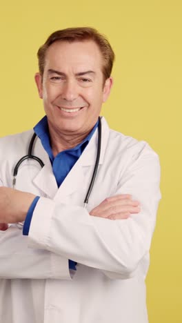 smiling male doctor with stethoscope and crossed arms