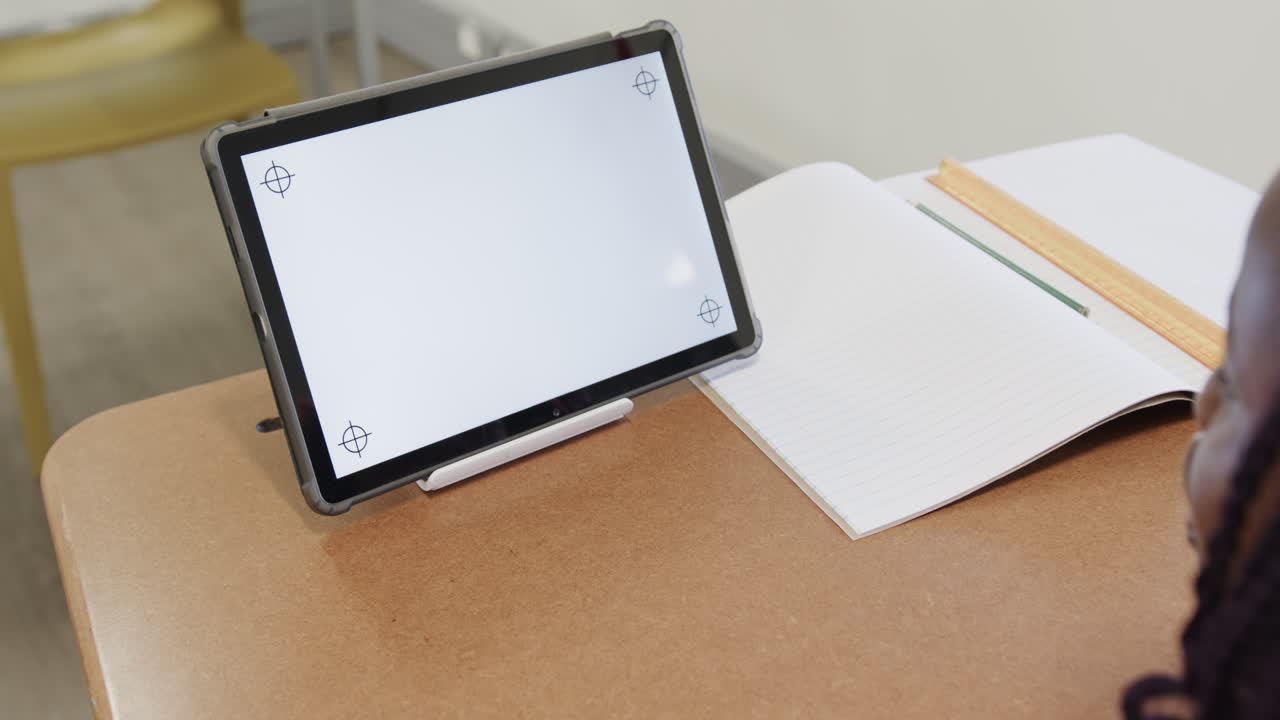 Tablet on desk beside open notebook and ruler in school classroom, copy space