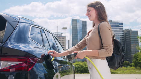 woman charging and locking her electric car near business center, handheld shot