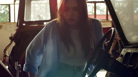 woman working on a vintage vehicle in a garage