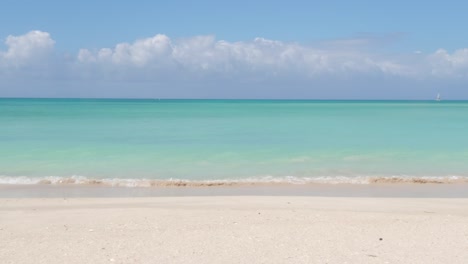 A-beautiful-beach-with-turquoise-water-and-small-waves-and-blue-sky