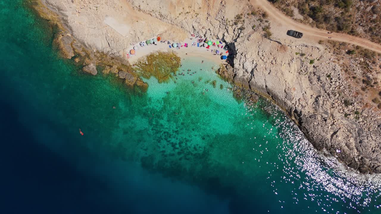 Secluded beach in Albania with few visitors and crystal-clear turquoise water, aerial view