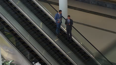 businessmen on an escalator in a modern building