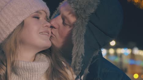 happy-guy-and-girl-kiss-at-fair-in-evening-city-slow-motion