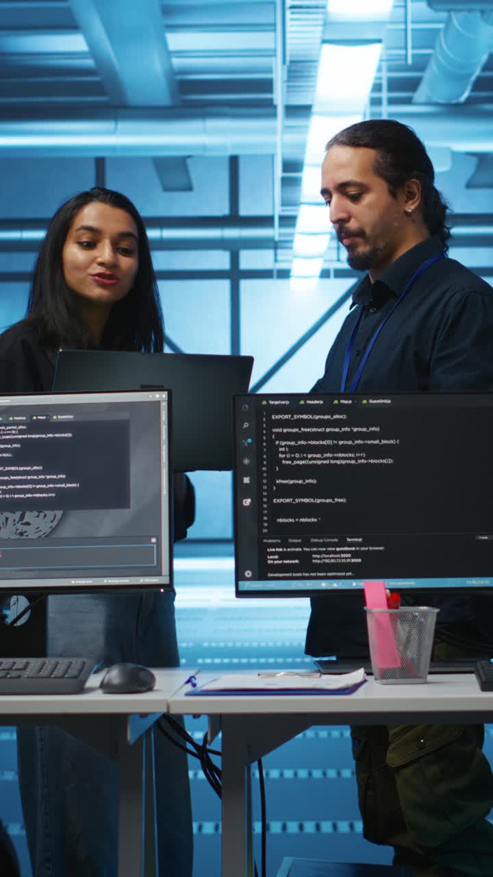 To programmerere diskuterer kode i et serverrom