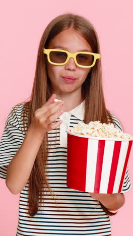 child girl kid happily eating popcorn while watching funny cartoon laughing and smiling cheerfully