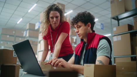 Warehouse Workers Checking Orders on Laptop