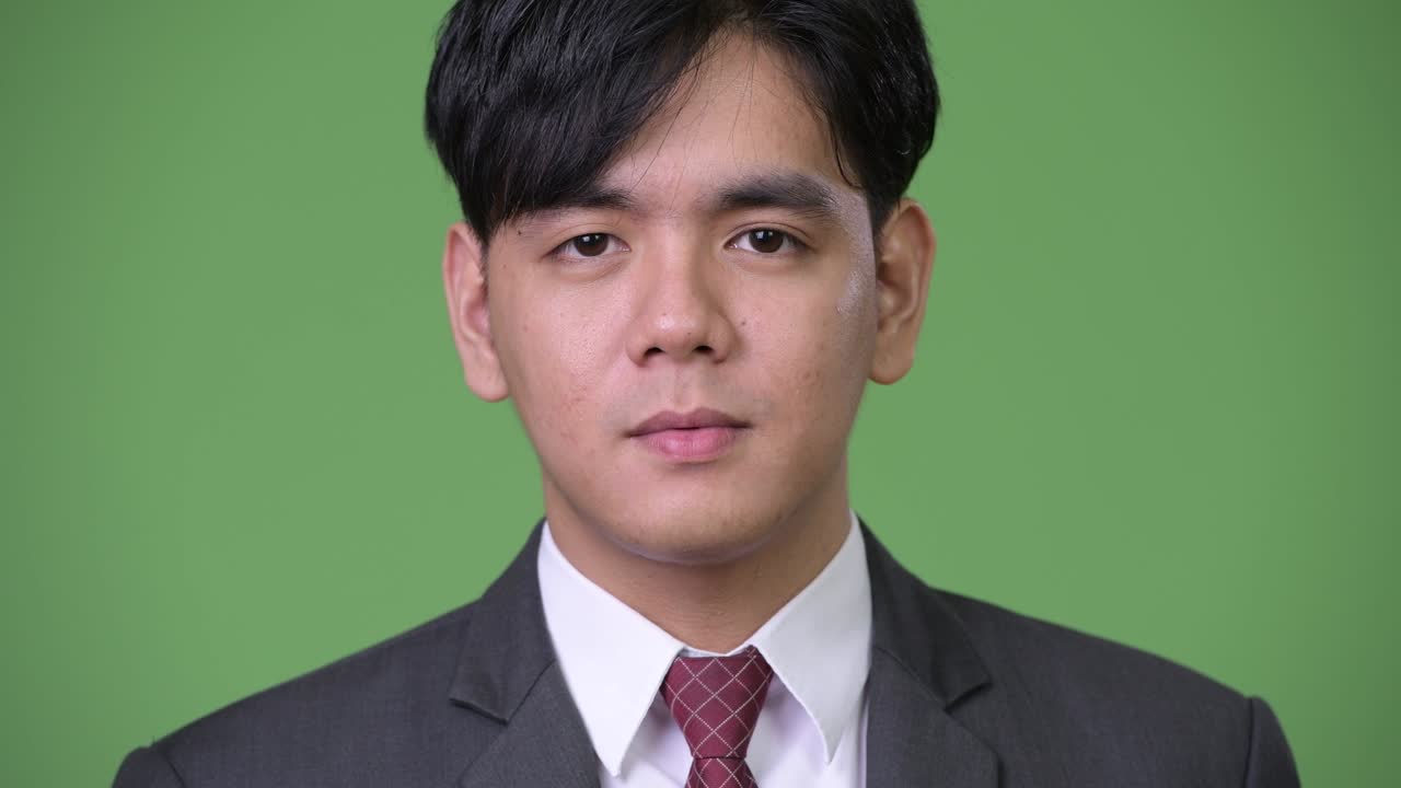 젊은 잘생긴 아시아 사업가가가 충격을 받았습니다.