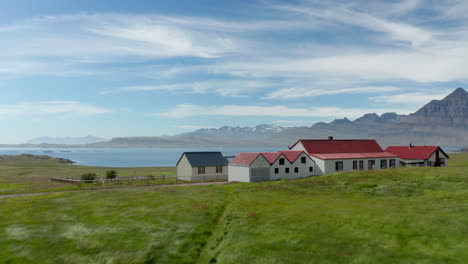 Vista-De-Pájaro-Del-Pequeño-Pueblo-Aislado-En-El-Campo-De-Islandia.-Vista-Aérea-De-Un-Pequeño-Asentamiento-En-Las-Tierras-Altas-De-Islandia