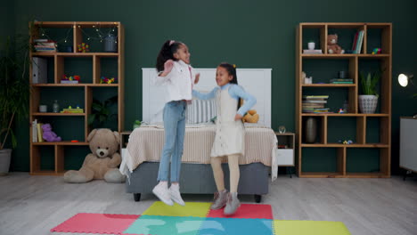 two young girls playfully jumping in bedroom