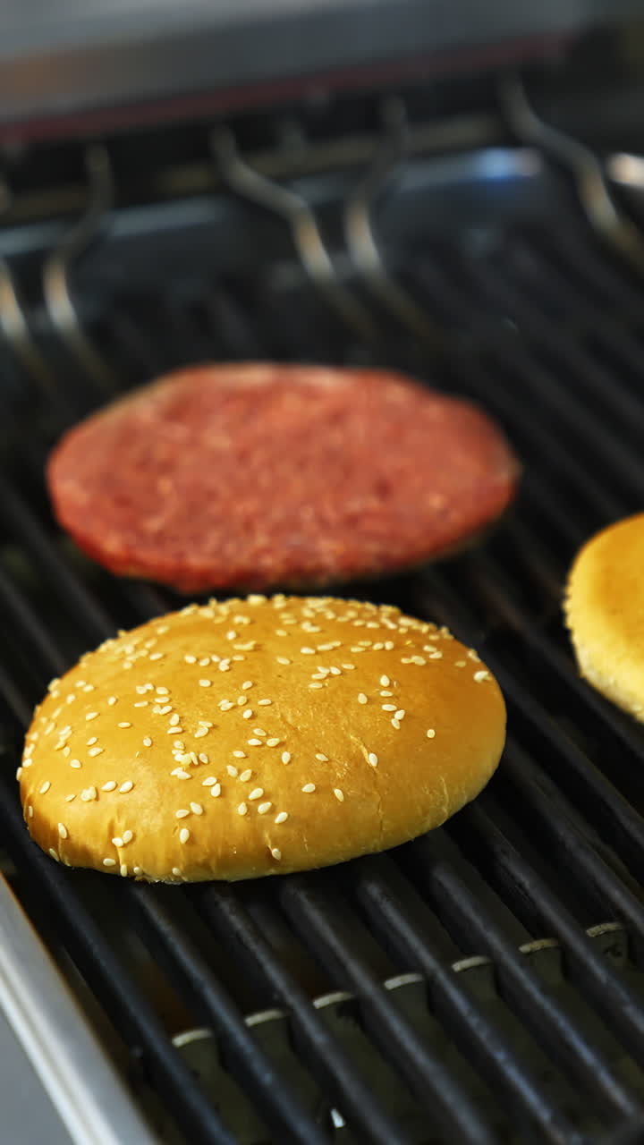 Two buns are grilled on a barbeque grid. Raw cutlet being fried on grill. Unhealthy tasty dish. Vertical video