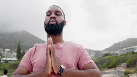 hombre negro, yoga y respiración en la playa