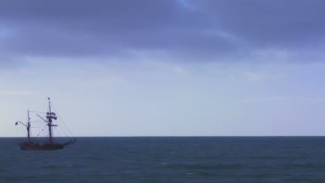 A-tall-masted-ship-sails-on-the-ocean-without-sails-unfurled