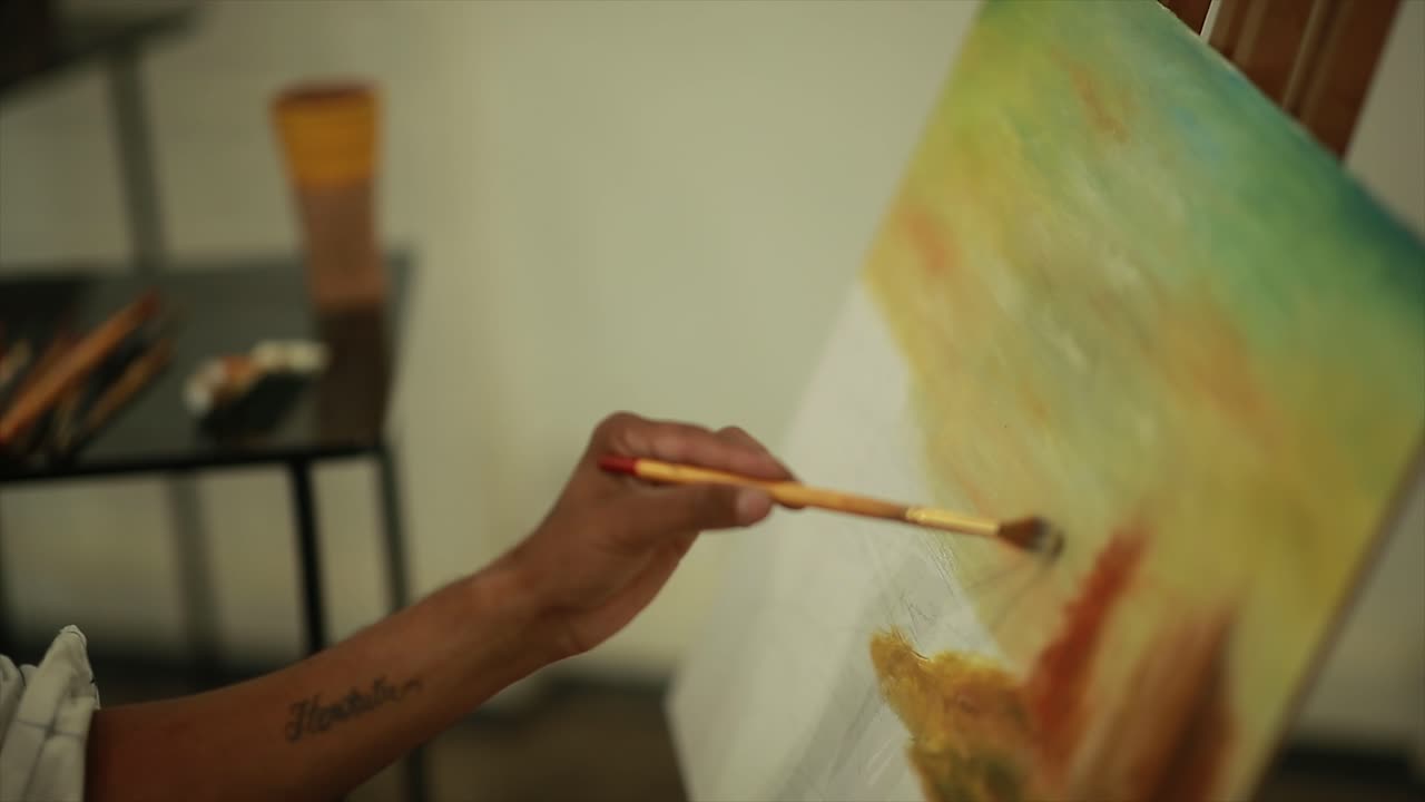 artista masculino creativo dibujando un cuadro con pinturas al óleo en el estudio