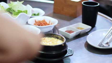 people sharing and preparing a korean meal together