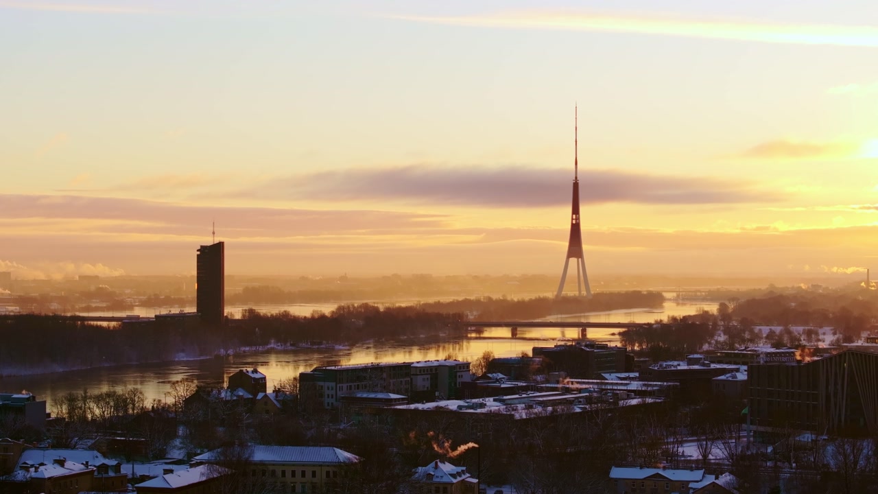 Golden sunrise over Riga TV tower, Daugava river reflecting winter light