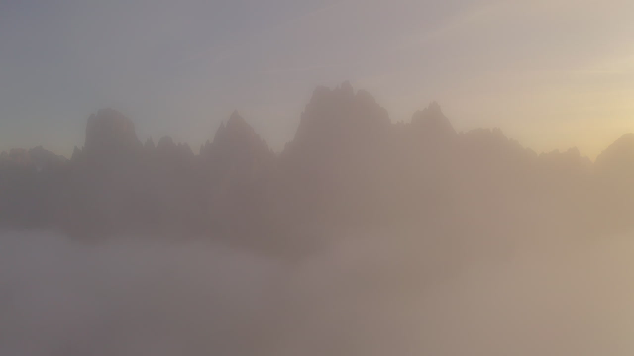 유령 같은 구름이 퇴색하여 tre cime dolomites 산맥의 공중 전망을 햇볕에 쬐인 남쪽 티롤 알프스로 향합니다.