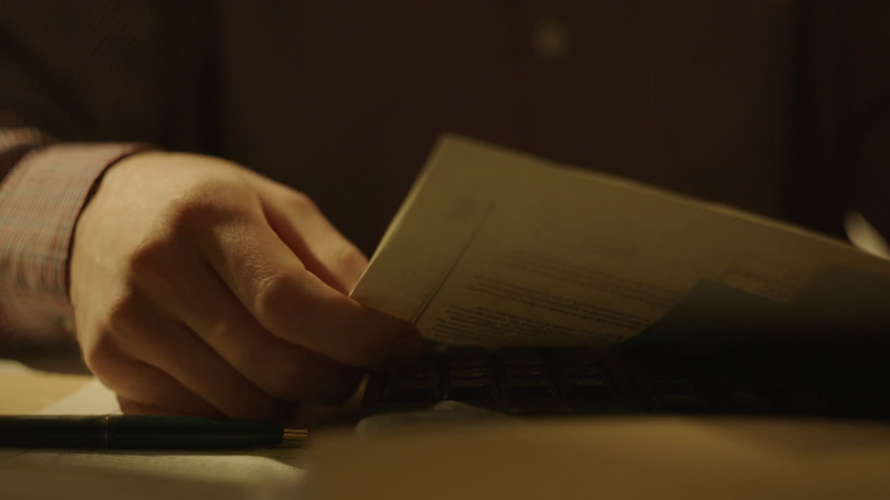 Person Reading Documents at Night
