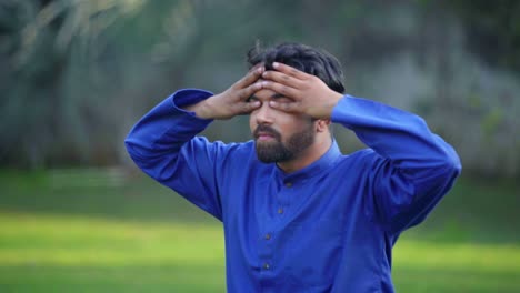 joven indio haciendo ejercicio de respiración en un parque